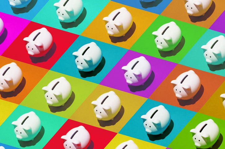 Little white ceramic piggy banks on multi-colored grid, high angle of view (Getty/Getty Images)