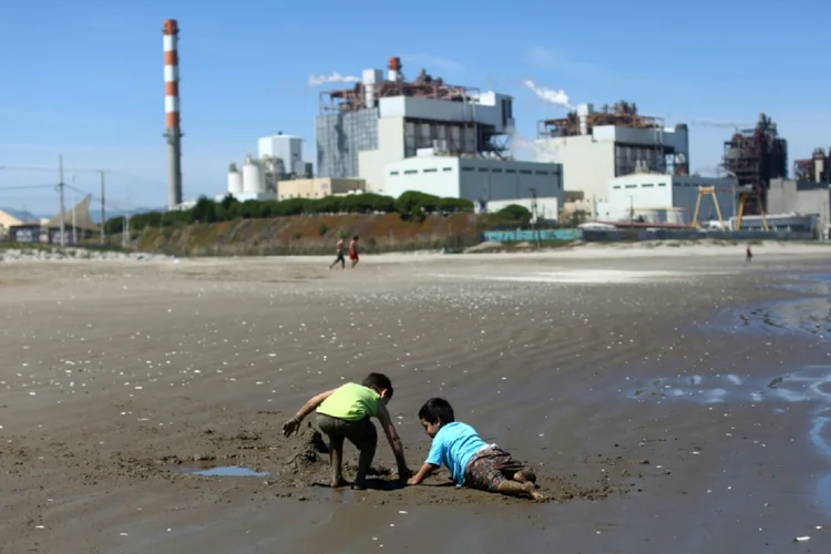 Crianças brincam na praia Las Ventanas de Puchuncaví, na região chilena de Valparaíso, perto da central termelétrica AES Gener, em 8 de outubro de 2019

 (AFP/AFP)
