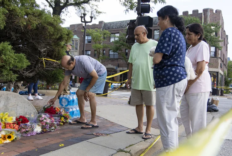 Highland Park resident Kernel Parikh, left, leaves flowers near the Central Avenue crime scene on July 5, 2022, the day after a mass shooting at the Fourth of July parade in Highland Park. (Brian Cassella/Chicago Tribune/Tribune News Service via Getty Images) (Tribune News/Getty Images)