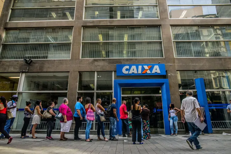 Customers stand in line to speak to an employee about withdrawing money from the Workers Severance Fund (FGTS) outside a Caixa Economica Federal bank branch in Sao Paulo, Brazil, on Friday, March 10, 2017. The Government releases from this Friday the withdrawals of inactive accounts of the Fund for the Guarantee of Time of Service (FGTS) - promised by President Michel Temer in (MP 763/16) is expected to benefit 30.2 million workers and to inject about 30 billion reais into the economy, according to the authorities. The branches of the Federal Savings Bank opened in advance, at 8 am (Brasília time), and were already registering rows. (Photo by Cris Faga/NurPhoto via Getty Images) (Cris Faga/Getty Images)