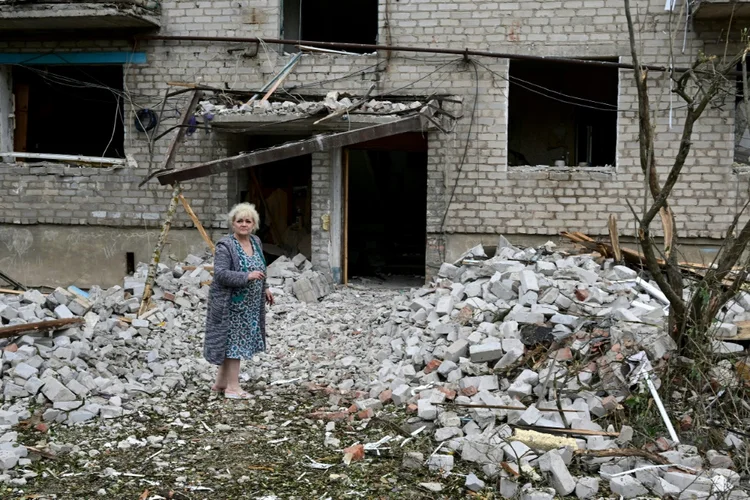 Ucraniana diante de edifício bombardeado em Chasiv Yar: ao menos 15 pessoas morreram (AFP/AFP)