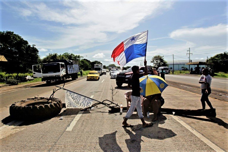 Manifestante leva bandeira do Panamá durante bloqueio na via Pan-americana, em Aguadulce, Panamá, em 15 de julho de 2022, durante dia de protestos contra a inflação e a corrupção (AFP/AFP)