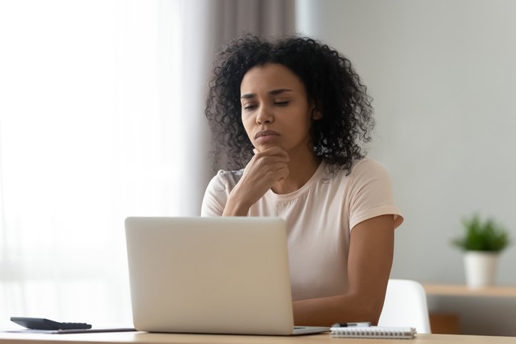 Pensive african American young woman sit at desk thinking studying or working on laptop at home, thoughtful black millennial girl student pondering considering idea looking at computer screen (Getty/Getty Images)