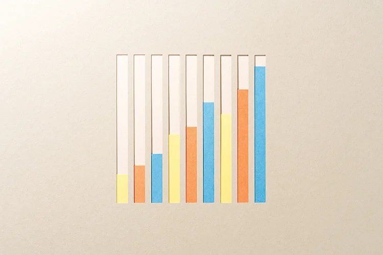 Paper Craft Ascending Multi-colored Bar Chart on Beige Background Directly above View. (MirageC/Getty Images)