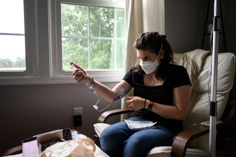 Walkersville, Maryland United States - May 27:
Mallory Stanislawczyk, a disabled former nurse practitioner who suffers from post-COVID POTs, gives herself a saline infusion through a PICC line in her Walkersville, Md. home Friday May 27, 2022.  she administers these infusions three times a week. The 34-year-old mother of a three-year-old used to run and take her daughter on hikes, but after Stanislawczyks bout of long COVID, she often only has enough energy to watch TV and cuddle with her daughter. We were going to be that no TV family, Stanislawczyk said, but long COVIDs effects on her autonomic nervous system, making it hard for her to stand up and not pass out. Now, she has to use a wheel chair.

(Photo by Matt Roth for The Washington Post via Getty Images) (Matt Roth/Getty Images)