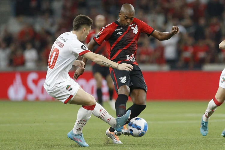 Argentina's Estudiantes de La Plata Benjamin Rollheiser (L) and Brazil's Athletico Paranaense Fernandinho vie for the ball during their Copa Libertadores football tournament quarterfinals first leg match, at the Arena da Baixada stadium in Curitiba, Brazil, on August 4, 2022. (Photo by Albari Rosa / AFP) (Photo by ALBARI ROSA/AFP via Getty Images) (ALBARI ROSA/Getty Images)