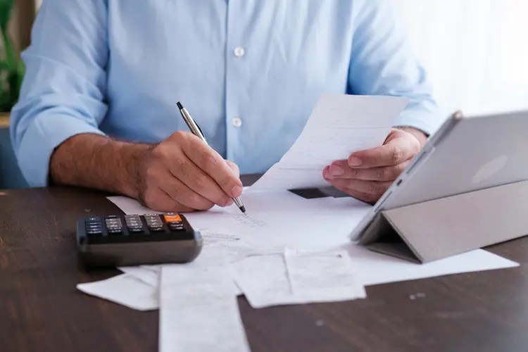 Man calculating personal expenses at home (Getty/Getty Images)