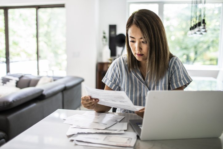 Woman paying bills at home (Getty/Getty Images)