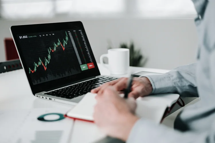 Young businessman using laptop for analyzing data stock market. He is working from home office - Stock market, investment and cryptocurrencies concept (Getty/Getty Images)