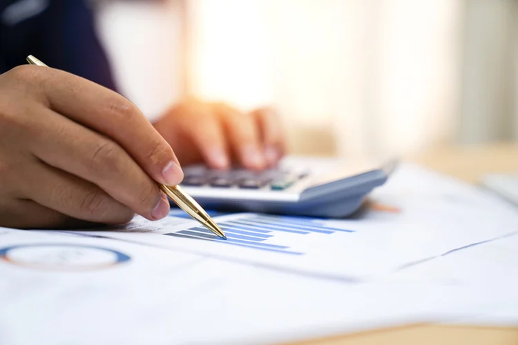 Businessman analyzing investment charts with calculator, Accounting,account,Accounting concept (Getty/Getty Images)