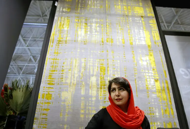 Mulher em frente a um tapete fabricado em Ispahan, em Teerã. (AFP/AFP)
