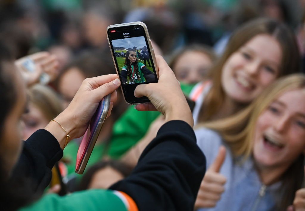 Jovens tirando foto no BeReal: app captura imagens simultâneas da câmera frontal e traseira (Stephen McCarthy/Sportsfile/Getty Images)