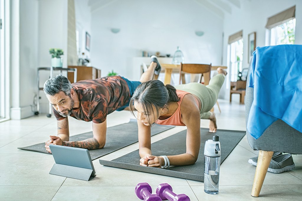 Mixed race couple practicing stretching exercise at home