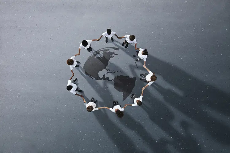Group of children photographed from above on various painted tarmac surface at sunset (Klaus Vedfelt/Getty Images)
