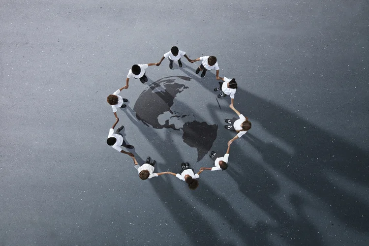 Group of children photographed from above on various painted tarmac surface at sunset (Klaus Vedfelt/Getty Images)