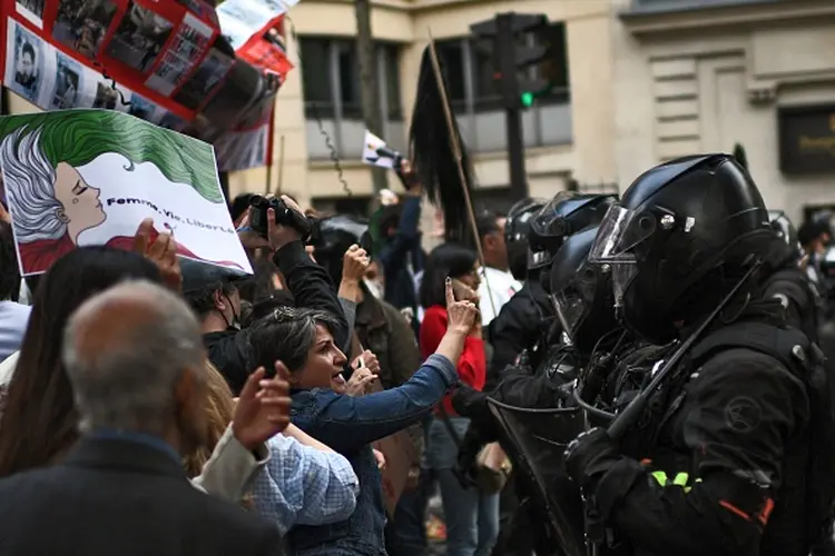 People face riot police as they take part in a demonstration in support of Iranian protesters in Paris, on September 25, 2022. - Protests flared again in Iran on September 24, 2022 over the death of a woman in morality police custody, despite a crackdown by security forces in which at least 41 people have died, according to official figures. The main reformist party inside Iran called for the repeal of the mandatory Islamic dress code that Mahsa Amini had been accused of breaching as the protests over her death entered their ninth night. (Photo by Christophe ARCHAMBAULT / AFP) (Photo by CHRISTOPHE ARCHAMBAULT/AFP via Getty Images) (CHRISTOPHE ARCHAMBAULT/AFP via Getty Images/Getty Images)