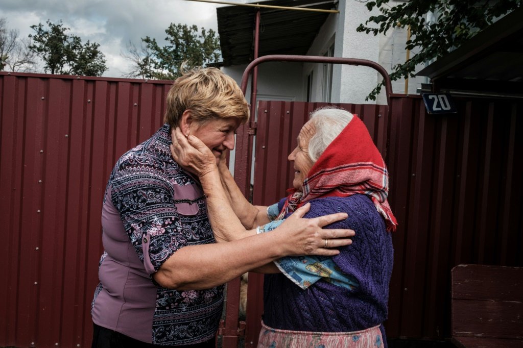Olga Valkova (à esquerda), de 64 anos, se reúne em 18 de setembro de 2022 com sua irmã Garina Nazorenko, de 80 anos, na cidade de Troitske, região de Kharkiv, após ser reconquistada pelo exército ucraniano (AFP/AFP Photo)