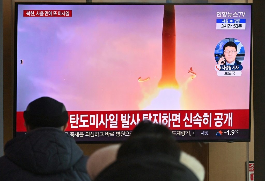 (Janeiro) Passageiros em estação de trem sul-coreana assistem a imagens de arquivo de um teste militar da Coreia do Norte (AFP/AFP)
