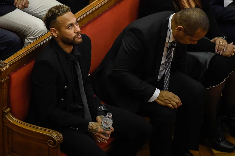 Paris Saint-Germain's Brazilian forward Neymar (L) attends the opening audience with his father Brazilian former footballer Neymar Senior (R) at the courthouse in Barcelona on October 17, 2022, on the first day of their trial. - With the World Cup barely a month away, Brazilian superstar Neymar goes on trial in Spain over alleged irregularities in his transfer to Barcelona nearly a decade ago. The 30-year-old was acompanied by his parents, who are also in the dock on corruption-related charges over his 2013 transfer from the Brazilian club Santos. (Photo by Josep LAGO / AFP) (Photo by JOSEP LAGO/AFP via Getty Images) (JOSEP LAGO/Getty Images)