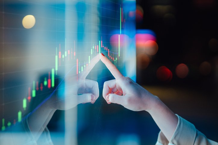 Close-up of female hand touching illuminated display screen, managing investment with financial date. Crypto-asset management. (Getty/Getty Images)