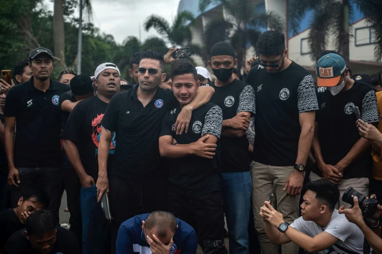 Jogadores e técnicos do Arema FC rezam pelas vítimas da tragédia no estádio Kanjuruhan de Malang (AFP/AFP Photo)