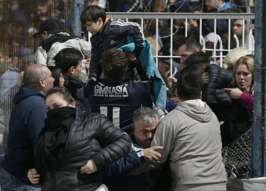 Pessoas tentam escapar do gás lacrimogêneo no estádio em 6 de outubro de 2022 em La Plata, Argentina (AFP/AFP Photo)