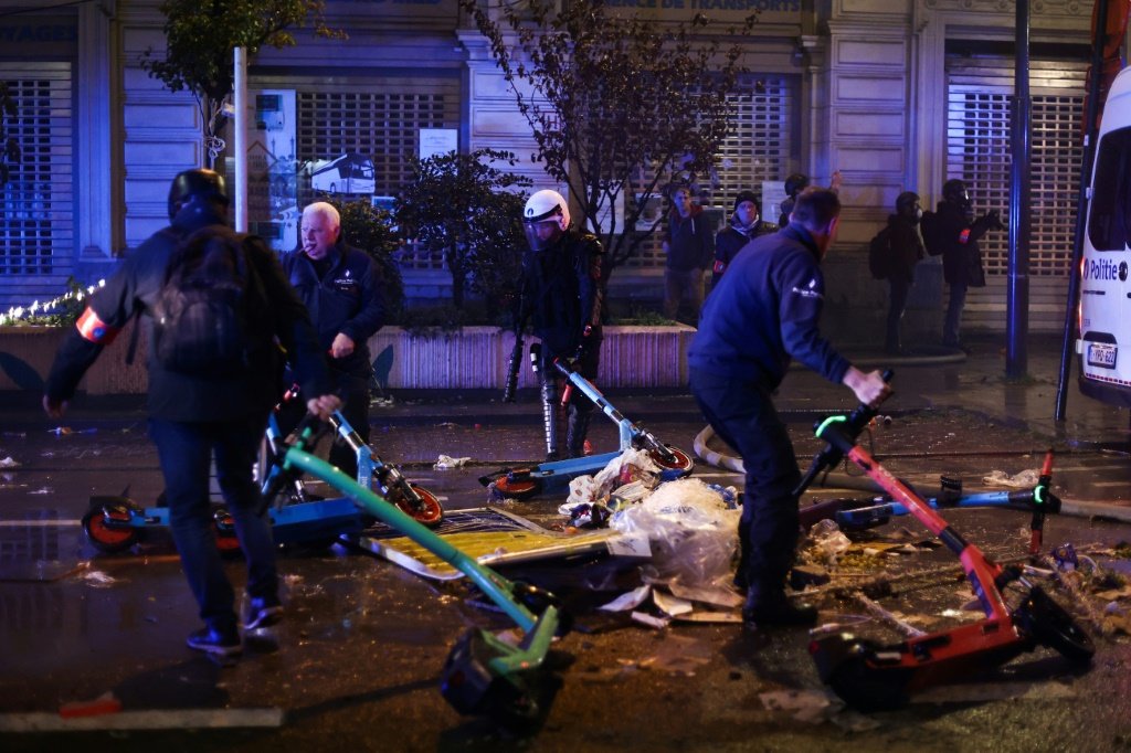 Bélgica: agentes limpam rua de Bruxelas após vandalismo (Agence France-Presse/AFP Photo)