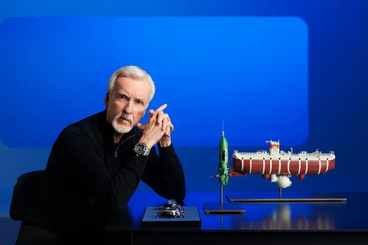 James Cameron, cineasta e diretor do filme Titanic, ao lado de uma maquete do navio (Rolex/Divulgação)