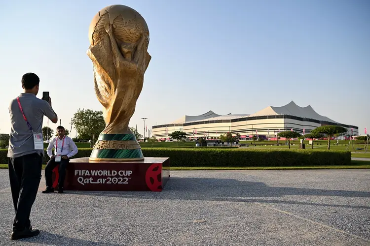 A man takes a picture of a FIFA World Cup trophy replica in front of the Al-Bayt Stadium in al-Khor on November 10, 2022, ahead of the Qatar 2022 FIFA World Cup football tournament. (Photo by Kirill KUDRYAVTSEV / AFP) (Photo by KIRILL KUDRYAVTSEV/AFP via Getty Images) (KIRILL KUDRYAVTSEV/AFP/Getty Images)