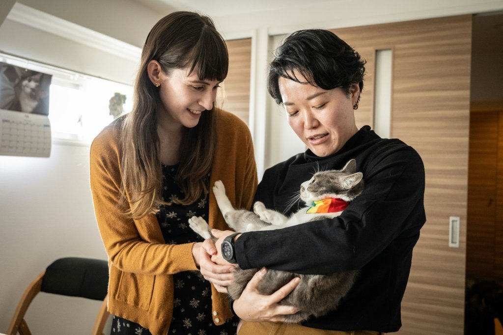 O casal Miki (d) e Katie acaricia seu gato de estimação (Tomohiro OSAKI/AFP Photo)
