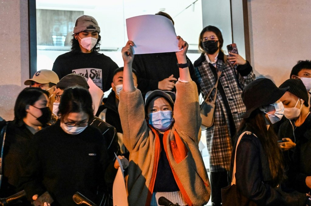 Protestos contra covid zero: manifestante exibe folha em branco durante protesto em Xangai, em 27 de novembro de 2022 (AFP/Reprodução)