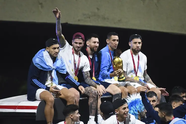 BUENOS AIRES, ARGENTINA - DECEMBER 20:  (L-R) Leandro Paredes, Rodrigo De Paul, Lionel Messi, Angel Di Maria and Nicolas Otamendi celebrate on the bus during the arrival of the Argentina men's national football team after winning the FIFA World Cup Qatar 2022 on December 20, 2022 in Buenos Aires, Argentina. (Photo by Rodrigo Valle/Getty Images) (Rodrigo Valle/Getty Images)