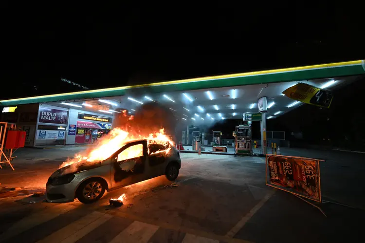 Carro queimado durante protestos antidemocráticos em Brasília nesta segunda-feira, 12 de dezembro (Evaristo Sá/AFP)
