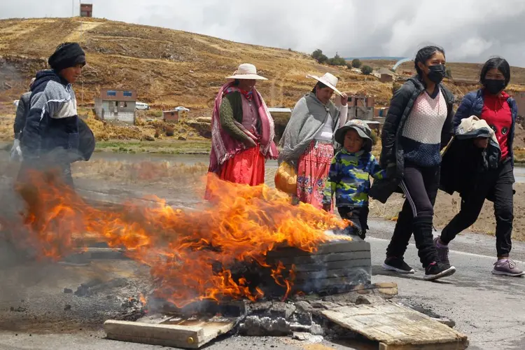 Andean peasants, supporters of former President Pedro Castillo, block the road leading to the Ilave International Bridge on the border between Peru and Bolivia in Puno, demanding the release of Castillo on December 13, 2022. - Former Peruvian president Pedro Castillo, who was removed from office and arrested last week on charges of rebellion and conspiracy, insisted Tuesday he would "never give up" his cause. Castillo also called on police and the military to "stop killing" protesters who continue to demand his release and reinstatement, after violent clashes between security forces and demonstrators left seven people dead in recent days. (Photo by Juan Carlos CISNEROS / AFP) (Photo by JUAN CARLOS CISNEROS/AFP via Getty Images) (JUAN CARLOS CISNEROS/AFP/Getty Images)