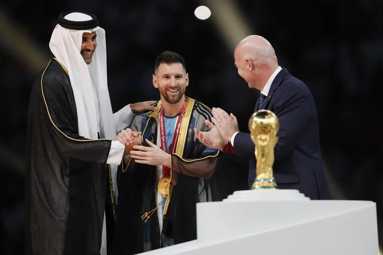 Messi: Capitão da seleção Argentina, vestiu uma roupa típica do Catar para levantar o troféu (Richard Sellers/Getty Images)