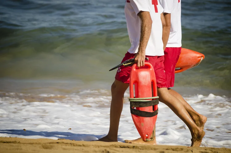 Lifeguards walking on the beach; no logos; outdoor photography. (AlenaPaulus/Getty Images)