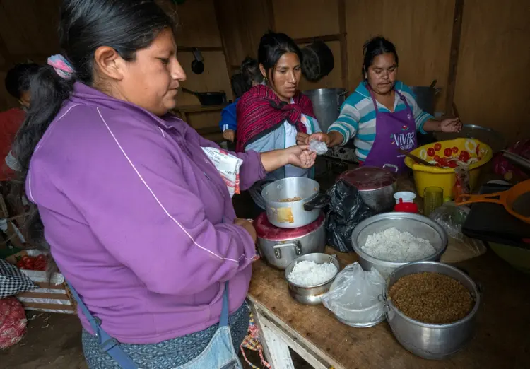 Peru: Pessoas fazem fila, enquanto Edith Acurio (C), de 44 anos, e Emilian Bernal, de 28 (D), servem lentilhas, arroz e salada em um refeitório popular (AFP/AFP Photo)