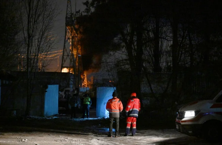 Equipes de resgate tentam apagar um incêndio em uma infraestrutura elétrica de Kiev atacada por drone em 19 de dezembro de 2022 (AFP/AFP Photo)
