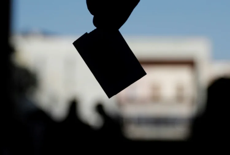 Uma pessoa deposita seu voto durante o referendo constitucional em 4 de setembro de 2022, em uma seção eleitoral em Santiago, Chile (AFP/AFP Photo)