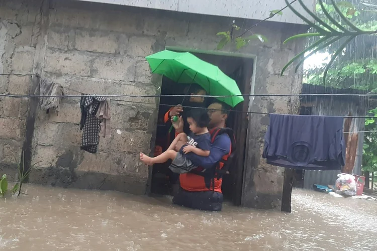 Agente da Guarda Costeira restata criança na cidade de Ozamiz, sul das Filipinas. (AFP/AFP)