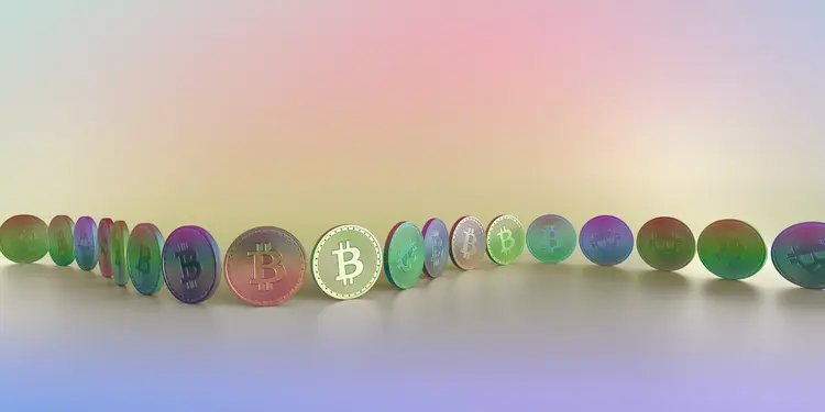 A pastel toned, multi-coloured image of two toned generic coin with Bitcoin symbol, arranged in a row, or chain along a curve against a multi coloured background. Denotes concept of block-chain and crypto-currency. With lots of copy space. (Getty Images/Reprodução)