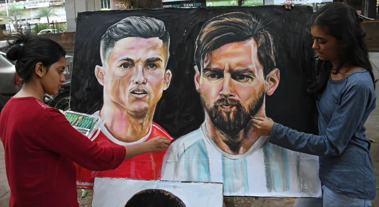 MUMBAI, MAHARASHTRA, INDIA - 2022/11/18: Students from Gurukul school of art paint posters of soccer players Cristiano Ronaldo and Lionel Messi ahead of the FIFA World cup 2022 to be held in Qatar. FIFA World cup will be held from 20th November till18th December 2022 in Qatar. (Photo by Ashish Vaishnav/SOPA Images/LightRocket via Getty Images) (LightRocket/Getty Images)