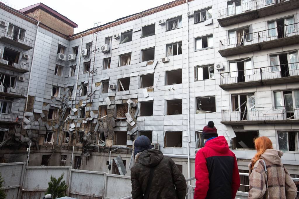 KYIV, UKRAINE - DECEMBER 30: People look at an administrative building damaged by a Russian drone attack in Kyiv, Ukraine, on December 30, 2022. Russia attacked Kyiv with drones in the early morning of Dec. 30. (Photo by Oleksii Chumachenko/Anadolu Agency via Getty Images) (Anadolu Agency/Getty Images)