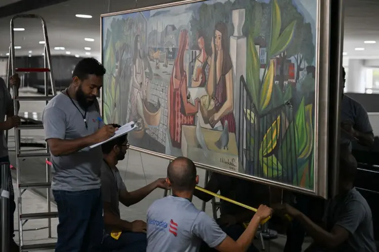 Trabalhadores fazem medições para substituir um espelho quebrado onde está pendurada uma pintura vandalizada do artista brasileiro Emiliano di Cavalcanti, no Palácio do Planalto, em Brasília. (CARL DE SOUZA/AFP/Divulgação)