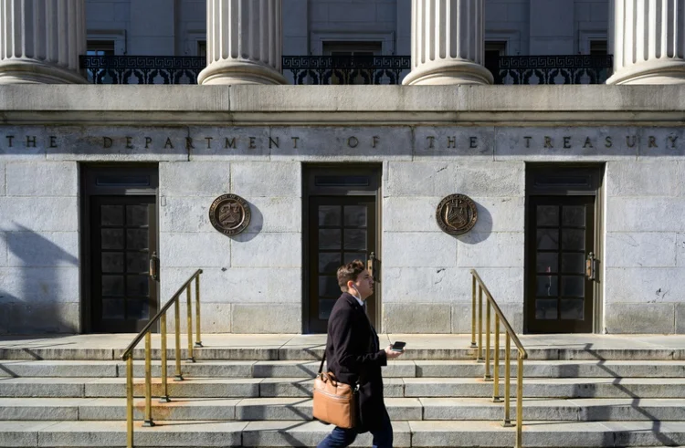 Pedestre caminha em frente ao prédio do Departamento do Tesouro dos Estados Unidos em Washington, em 18 de janeiro de 2023

 (AFP/AFP)