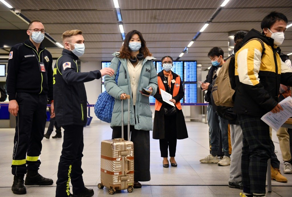 Passageiros de um voo procedente da China esperam em uma fila para verificação dos documentos comprobatórios de covid-19, no aeroporto Paris-Charles-de-Gaulle, em Roissy, em 1º de janeiro de 2023 (AFP/AFP)