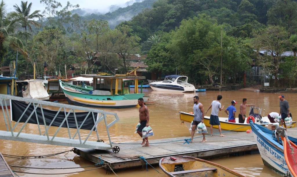 Turistas e moradores usam barcos para deixar São Sebastião após enchentes