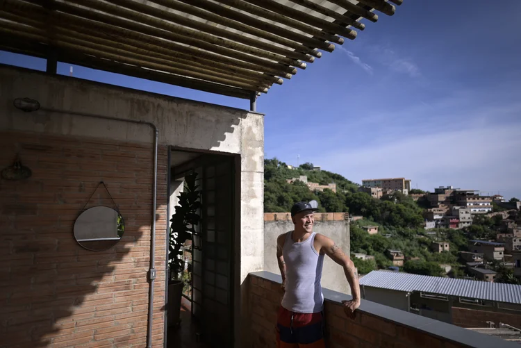 Brazilian musical artist Kdu dos Anjos looks at the distance from his house, which was designated "Building of the Year 2023" by the specialized reference site ArchDaily, in Aglomerado da Serra, a favela complex on the outskirts of Belo Horizonte, Minas Gerais State, Brazil, on February 24, 2023. - The 66 m² property, built by the Levante Collective, competed with buildings from India, Mexico, Germany and Vietnam. (Photo by Douglas MAGNO / AFP) (Douglas MAGNO / AFP/AFP Photo)