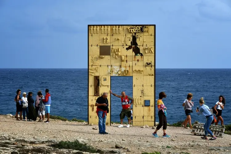 Itália: turistas diante da Porta de Lampedusa, conhecida como Porta da Europa, monumento na ilha italiana da Sicícilia em homenagem aos migrantes que morreram no mar (AFP/Site Exame)