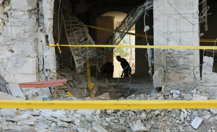Um homem varre os escombros após um ataque atribuído a Israel atingir a capital síria, Damasco, em 19 de fevereiro (Rouba EL HUSSEINI/AFP)